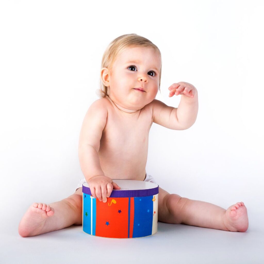 baby girl playing drum for a sensory music activity for babies