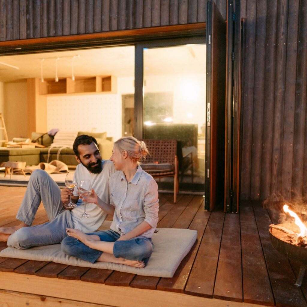 a couple enjoys a fire pit date night at home with wine