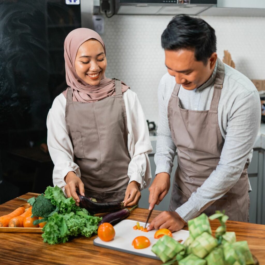 a woman and man chop vegetables together in their kitchen