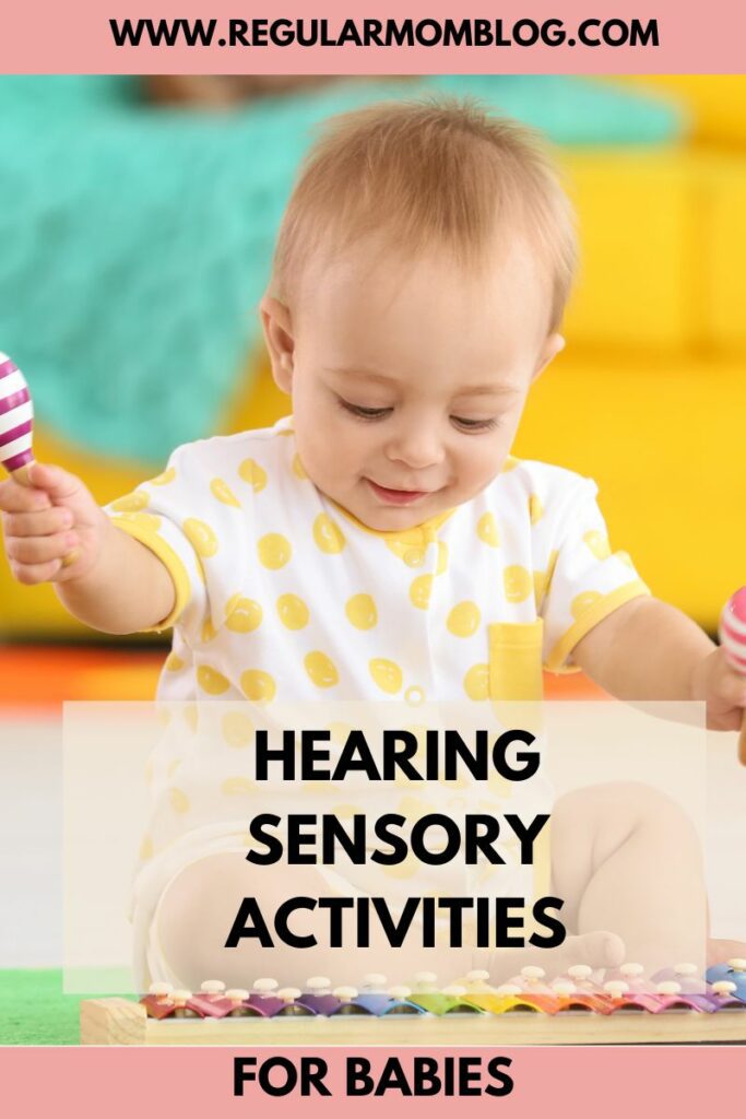 a baby plays with a xylophone on the floor as a hearing sensory activity