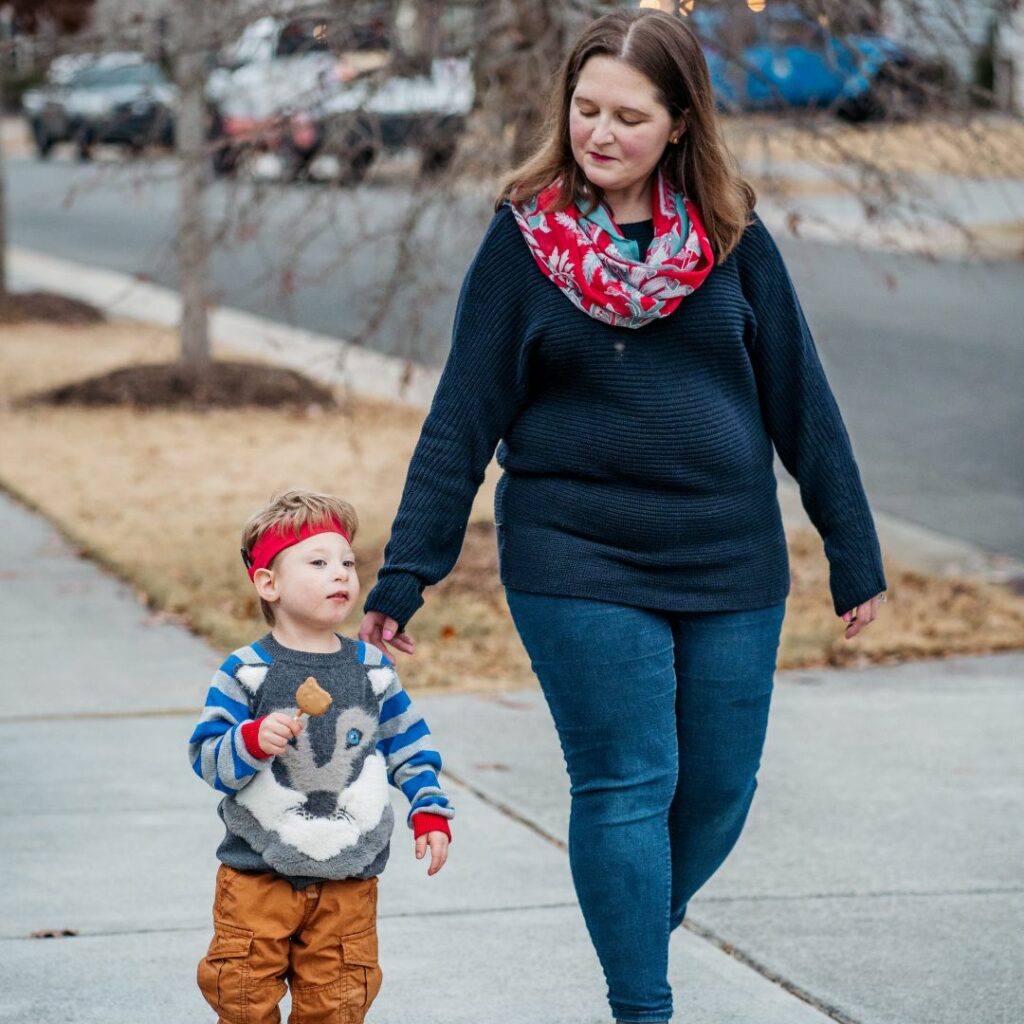 a mother walks outside beside of her son who is a kid with cochlear implants