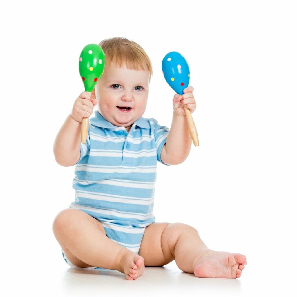 a baby plays with maracas for a 12 month sensory activity